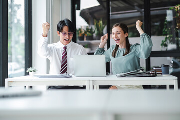 Business people celebrate with laptop success happy pose. E-commerce, internet technology, or startup small business concept. Modern office