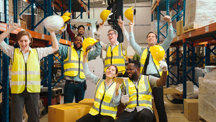 Multiracial warehouse workers in safety wear are dancing to relax after working hard on shipping...