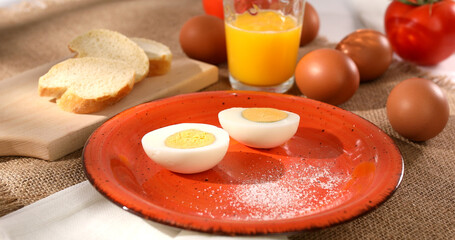 Eggs cut in half on a plate. breakfast on table. Boiled chicken eggs with bread and tomatoes. fresh eggs on the table. farm product closeup. natural healthy food. rustic still life on a sunny day.