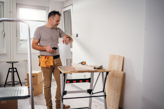 A handyman looking at his watch.