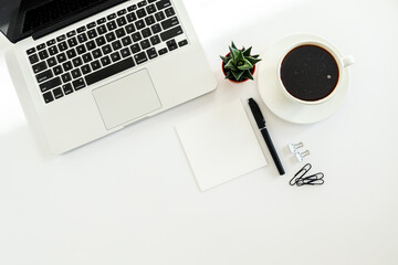 White office desk table with blank notebook, computer keyboard and other office supplies. Top view with copy space, flat lay.