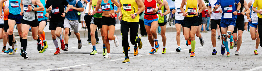 Naklejka premium large group male and female runners run marathon, athletes jogging city race in paving stones