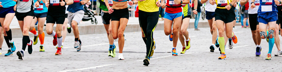 Fototapeta premium large group male and female runners run marathon city race in paving stones