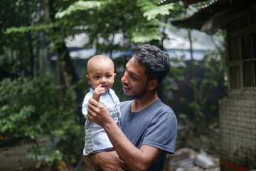 South asian young rural father holding his little son, village baby boy playing with his young dad,...
