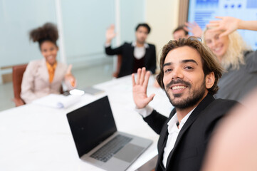 A diverse group of young business people taking selfies In the conference room of an international business company while waiting for the meeting to start