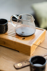 glass jug with brewed puer tea near traditional Japanese cup.