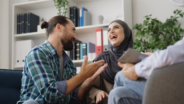 Smiling muslim couple talking during psychotherapist session, couples therapy