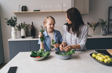 Mother and daughter cooking healthy meal in kitchen