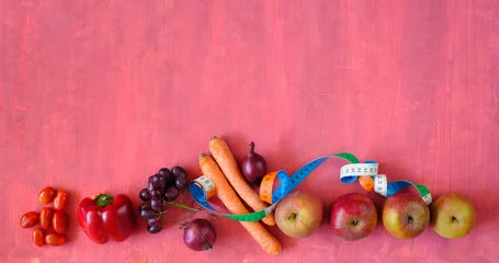 Foto auf Leinwand dieting and loosing weight for spring and summer,healthy food,water and measuring tape, flat lay, red background, free copy space © Kirsten Hinte