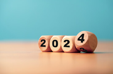 Flipping of 2023 to 2024 on wooden block cube for preparation new year change and start new...