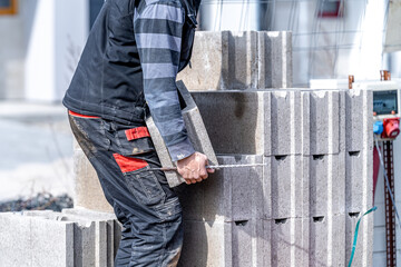 craftsman carries concrete bricks while building a house