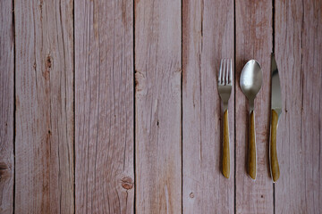Spoon, fork and knife on a rustic wooden table