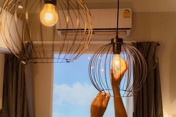 woman changing lightbulb in a lamp. Hands installing LED bulb in lamp, chandelier. An electrician...