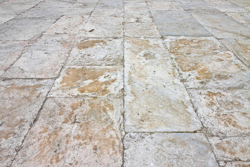 Old white limestone paving made with stone blocks of rectangular shape in a pedestrian zone