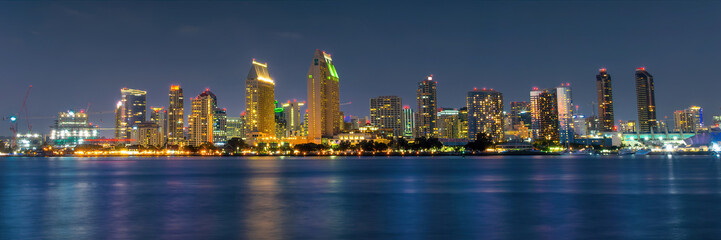 Panorama of San Diego skyline at night with water colorful reflections, view from Coronado island, California