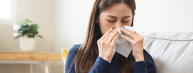 asian woman blowing nose and have allergy
