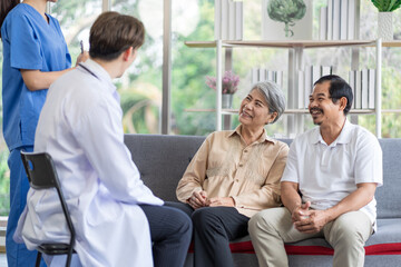 Asian couple Elderly men and women sit on sofas having fun and having fun talking with doctors who come to check their health at home.