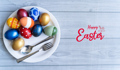Easter day concept with colorful eggs fork and spoon on a plate, Food and hotel Selective focus