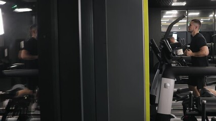 Body toning, Gym culture, Running routine. The gym member is running on a treadmill to stay in shape.