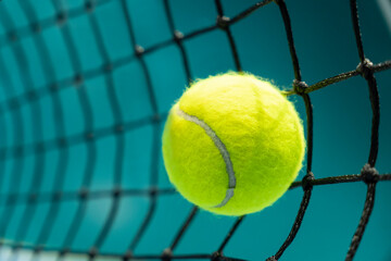tennis ball hit a black net on the background of a tennis court