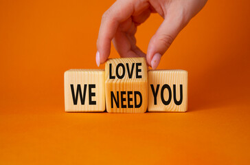 We love and need You symbol. Businessman Hand turns cubes and changes word We need you to We love you. Beautiful orange background. Business and We love and need You concept. Copy space
