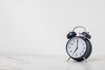 7 alarm clock on white table background with space for text.