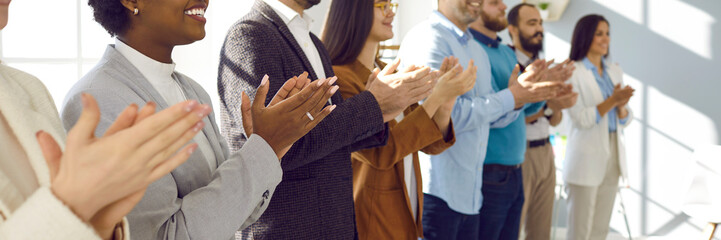 Diverse audience applauding at a public conference. Multiracial group of happy people smiling and clapping hands to express respect and gratitude to an interesting business lecturer. Header background - obrazy, fototapety, plakaty