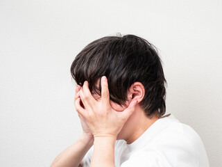 Fototapeta premium 両手で顔を覆う男性