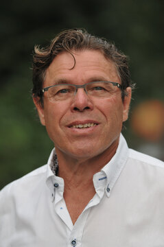 Outdoor portrait of 60 year old man wearing white shirt and eyeglasses