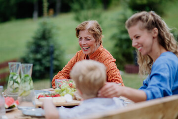 Multi generation family having outdoor garden party.