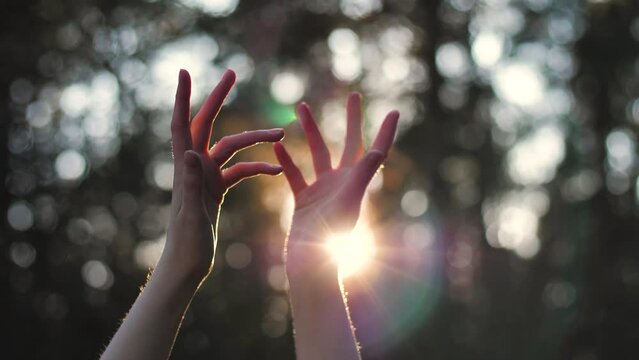 Close up girl dance with her arms to sun against background on forest