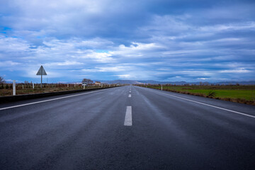 Fototapeta premium rain-soaked highway and blue sky with clouds