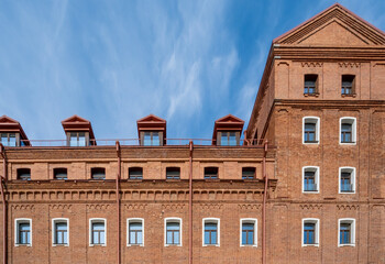 Fototapeta premium The wall of an old multi-storey brick building.