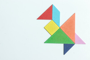 color tangram puzzle in flying young bird shape on white background	
