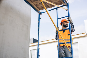 Foreman climbing ladder at building object