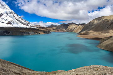 Naklejka na ściany i meble The deep luminescent blue of one of the highest lakes in the world - Tilicho Lake at 4910 meters above sea level, just below Tilicho peak, on the Annapurna circuit trek