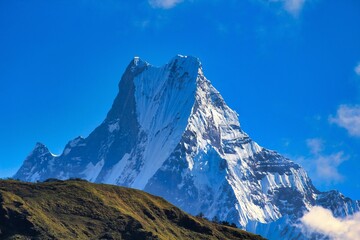 Magnificient Mount Machhapuchhare at 6993 meters rises over the lower villages on the trek towards Annapurna Base camp trek - obrazy, fototapety, plakaty