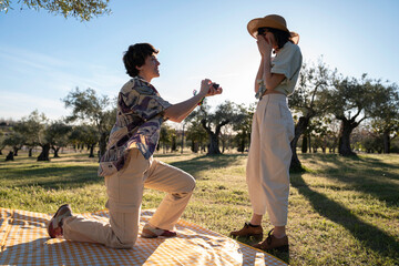 proposal marriage kneeling ring couple Lgbt lesbian women surprise in nature having picnic