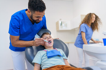 Fototapeta premium Liitle boy sitting on a dentists chair during dentist examination.