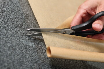 Obraz premium Chef cutting baking parchment with scissors