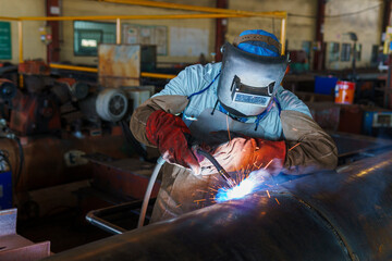 Welder is welding added joint a pipe carbon for steel structure work with process Flux Cored Arc...