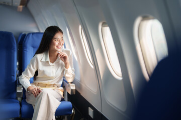 Asian attractive business woman passenger sitting on business class luxury plane while relax while...