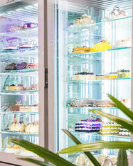 Varieties of homemade cakes in a refrigerator in a pastry shop