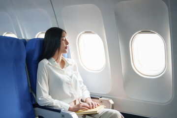 Asian attractive business woman passenger sitting on business class luxury plane while relax while travel concept