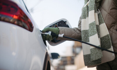 Close up of urecognizable person charging electric car.