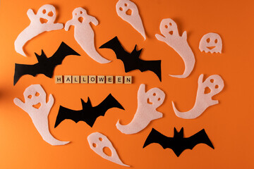 White ghosts and bat craft for Halloween party. Wrapping paper ghost on orange background top view. Cartoon creepy Whisper. DIY hand made. Set boo characters. Word wooden letter phrase.