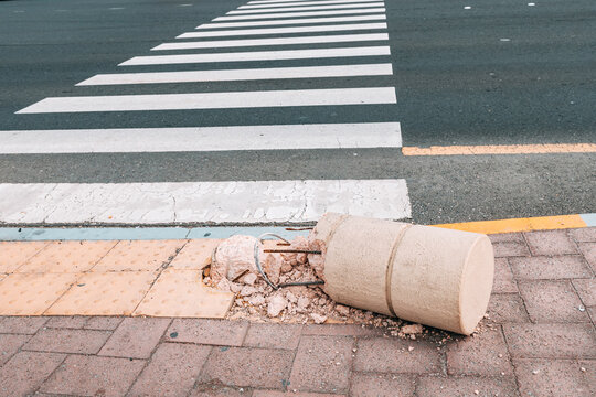 Car accident at pedestrian zebra crossing. Broken and crashed barrier pillar