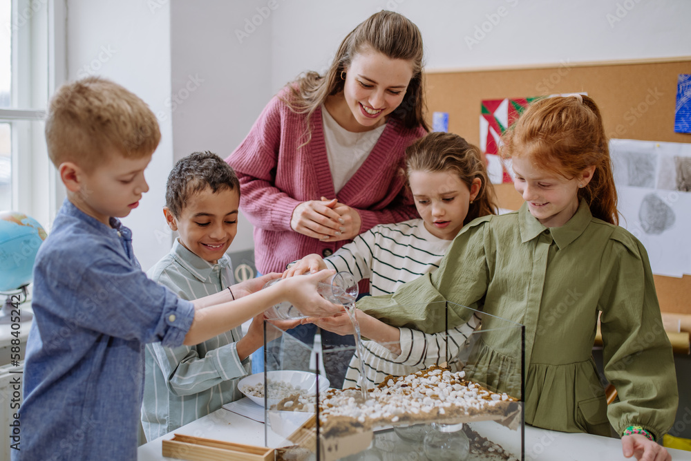 Canvas Prints young teacher making little greenhouse with their pupils, learning them about planting.