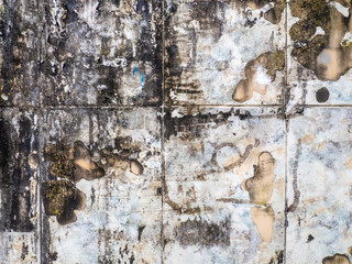  Background from a shabby wall. Old white cracked tiles. Blackened tiles. After the fire.