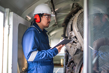 Engine engineer inspecting large machines in factory,Railway engine maintenance technician,engine repair mechanical manager